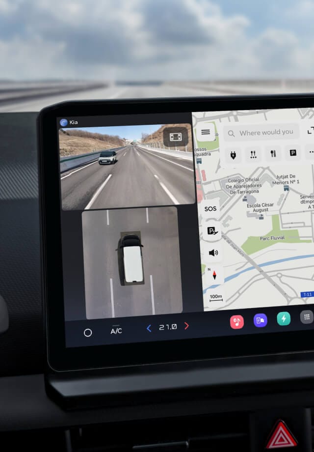 Nahaufnahme des Infotainment-Bildschirms mit Navigationskarte und Rückfahrkameraansicht.